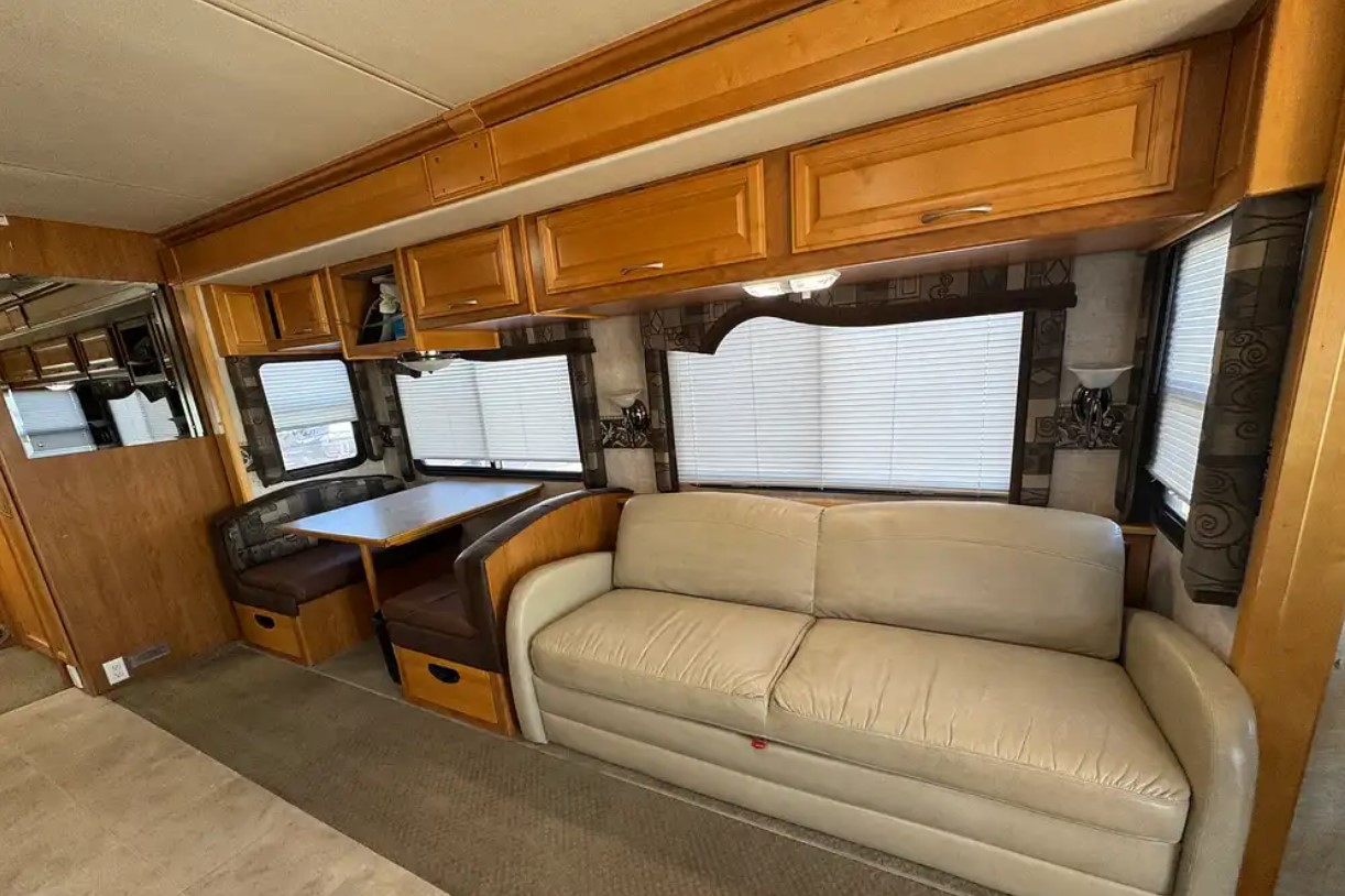 2005 Fleetwood Discovery 39L — sofa and overhead cabinetry in the living area