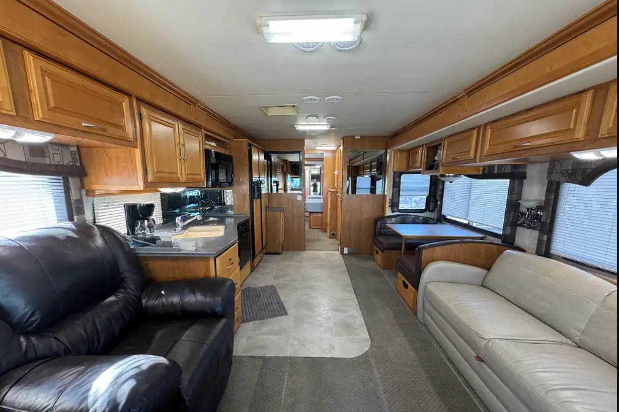 2005 Fleetwood Discovery 39L — living area with leather recliner and sofa in the slide-outs