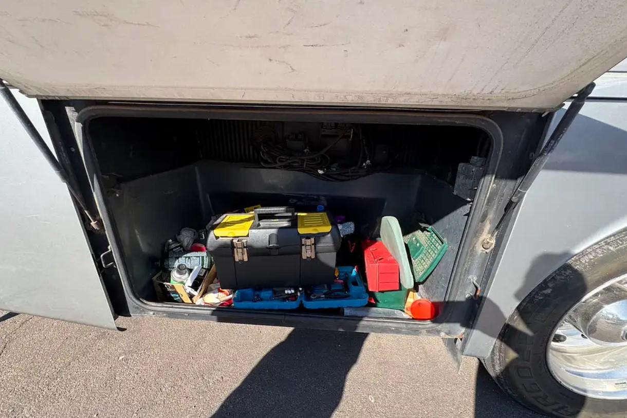 2005 Fleetwood Discovery 39L — exterior storage bay with tools and gear